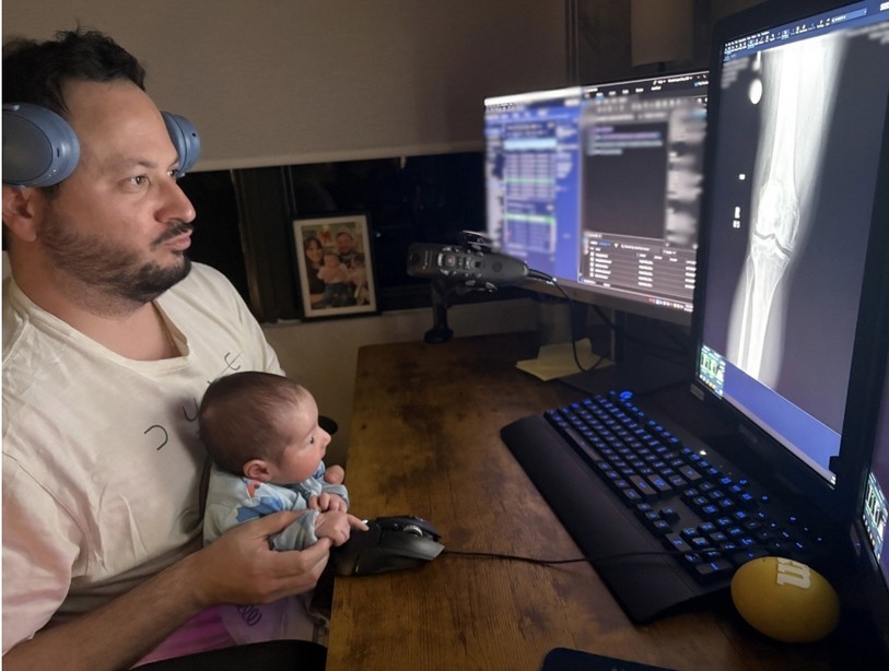 Dr. Ricardo López leyendo estudios en casa con su bebé